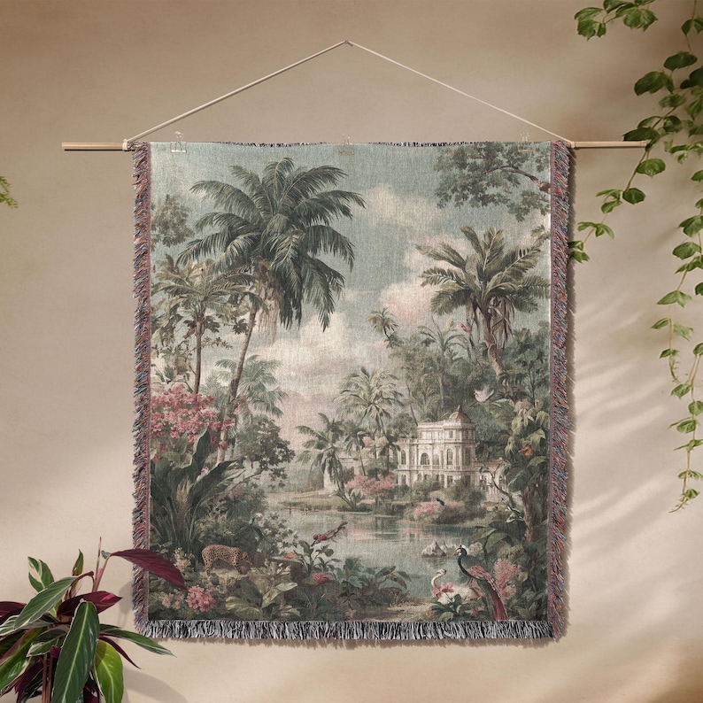 Pu&ograve; includere: Un arazzo da parete tessuto raffigurante un paesaggio tropicale con palme, un lago e un edificio bianco. L'arazzo ha un bordo sfrangiato ed &egrave; sospeso a un'asta di legno. La tavolozza dei colori comprende sfumature di verde, blu, rosa e beige.