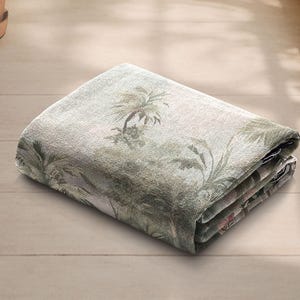 Pu&ograve; includere: Coperta rettangolare piegata con una stampa di foresta tropicale nei toni del verde, beige e marrone. La coperta presenta un design dettagliato di palme e altro fogliame. Il tessuto sembra essere un materiale tessuto.