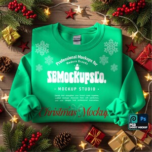 May include: A green sweatshirt with white snowflake designs and the text "Professional Mockups for Modern Brands" and "SB Mockups Co." in white. The words "Christmas Mockup" are in red. The sweatshirt is surrounded by Christmas decorations.