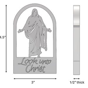 May include: A silver-colored metal religious wall hanging. The design features a figure with outstretched arms within an arched frame. The text "Look unto Christ" is below the figure. The wall hanging is 4.5 inches tall, 3 inches wide, and 0.5 inches thick.