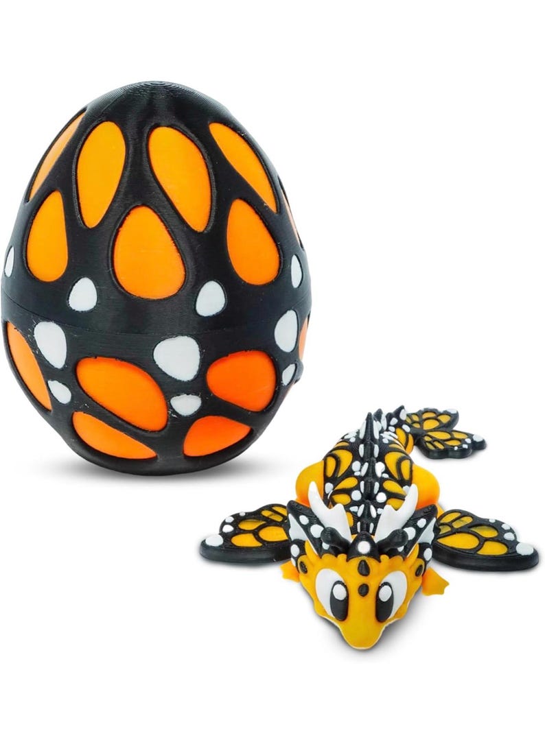 May include: A black and orange egg-shaped toy with a patterned design, next to a yellow and black dragon toy. The egg has orange cutouts and white dots. The dragon has wings and a detailed design.