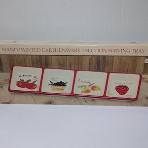 May include: A white ceramic mug with a black handle and the text "But First, Coffee" in a bold, black font. The mug is set against a blurred background, suggesting a cozy setting.