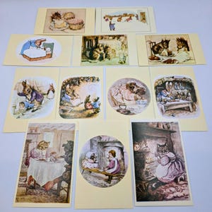 May include: A collection of vintage greeting cards featuring illustrations of rabbits, cats, and other animals in various scenes. The cards have a cream-colored background and depict scenes of animals in domestic settings.