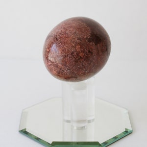 Vintage Brown Marble Stone Egg And Stand With Mirror.
Brown Marble Egg and Lucite Stand and 4-Inch Octagon Mirror. 
The Egg Has a Smooth, High Polish Finish.
The Stand is Clear Lucite.
Egg and Stand Measure 4 Inches.
The Gemstone Egg is 2 3/4 Inches by 2 Inches.
One More Really Nice Egg For your Collection.