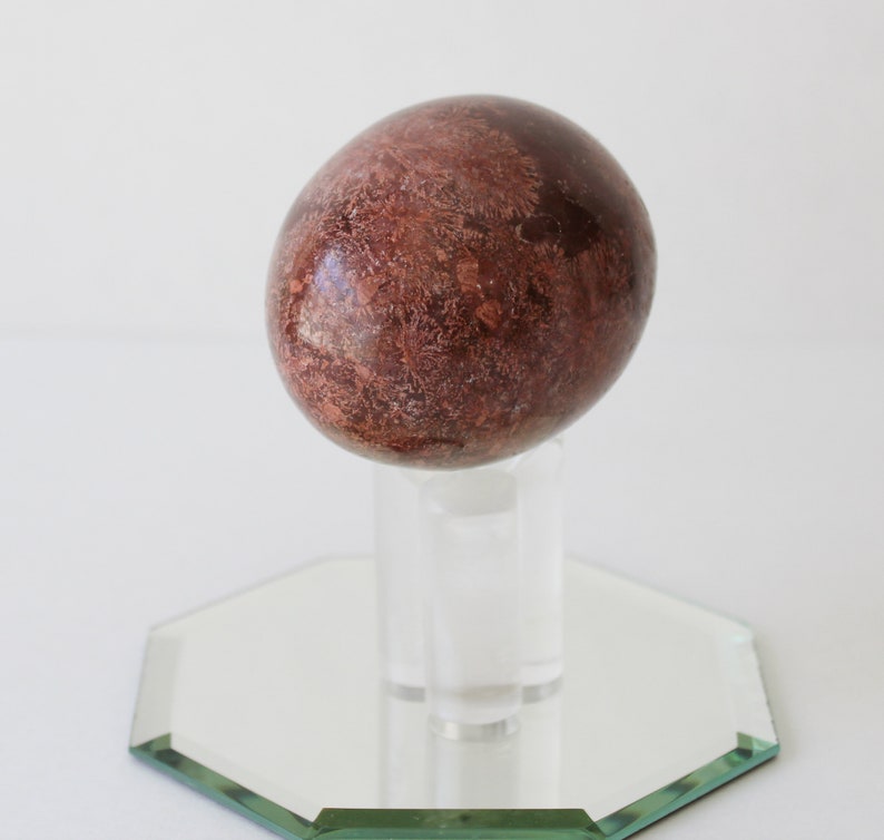 Vintage Brown Marble Stone Egg And Stand With Mirror.
Brown Marble Egg and Lucite Stand and 4-Inch Octagon Mirror. 
The Egg Has a Smooth, High Polish Finish.
The Stand is Clear Lucite.
Egg and Stand Measure 4 Inches.
The Gemstone Egg is 2 3/4 Inches by 2 Inches.
One More Really Nice Egg For your Collection.