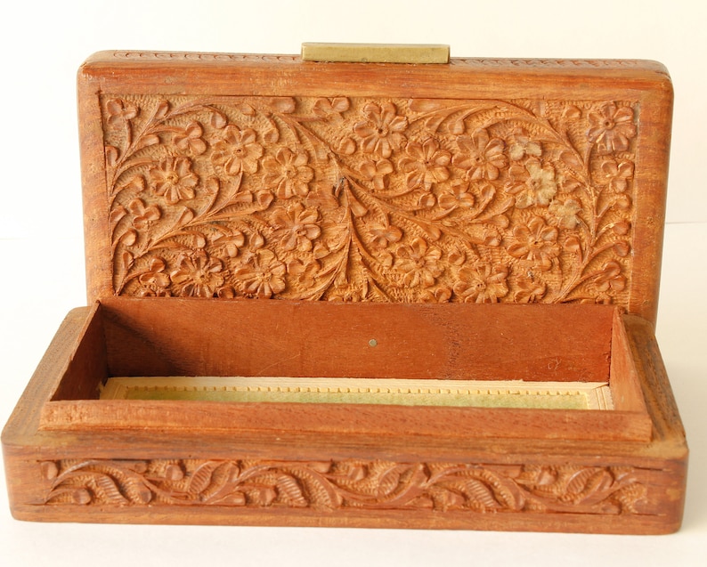 Wood Dresser Box Hand Carved Mahogany Box Lined Vintage 1960s.
Rich Hand-Carved Mahogany Dresser Box Featuring Brass Handles and Green Fabric Lining. 
The Lining is Very Old and Thin.
Wood Box Measures 6 7/8 Inches By 4 Inches By 1 1/2 Inches Tall.