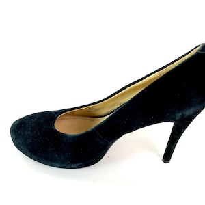 May include: A pair of black suede high heeled pumps.