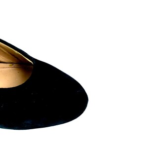 May include: Close-up of the top of a black suede shoe.