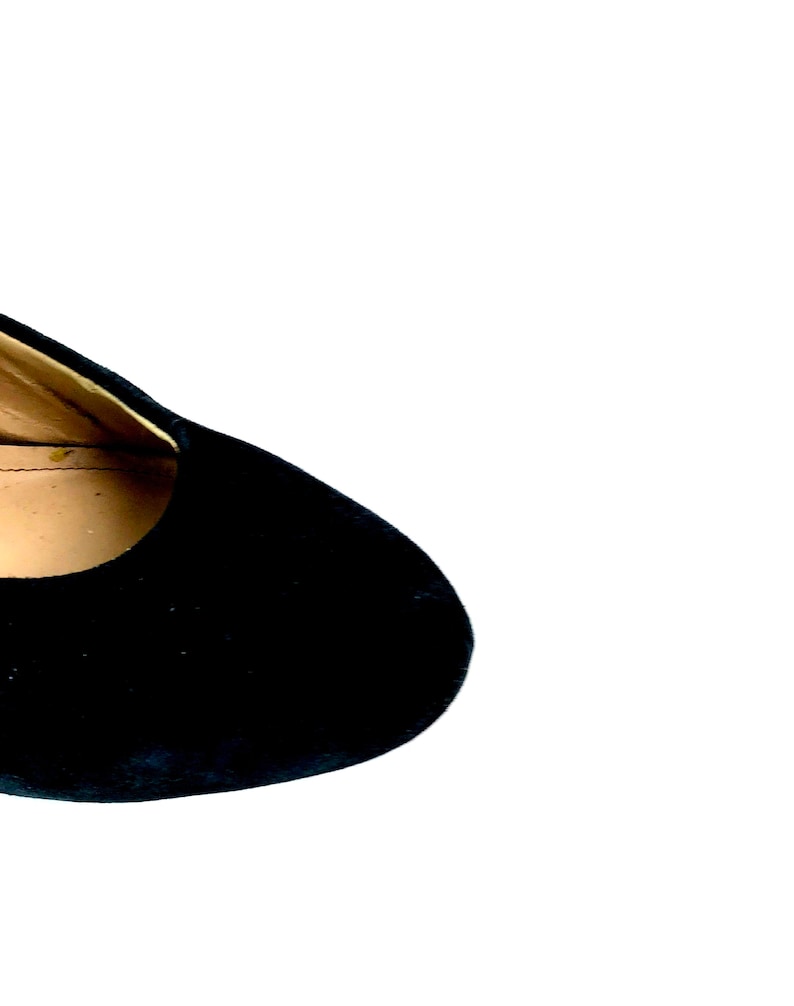 May include: Close-up of the top of a black suede shoe.