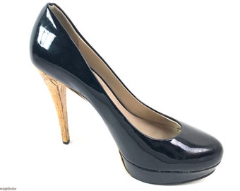 May include: Black patent leather pumps with a cork stiletto heel and a platform sole.