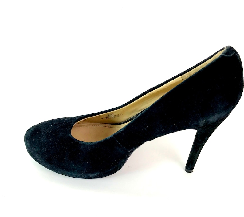 May include: A pair of black suede high heeled pumps.