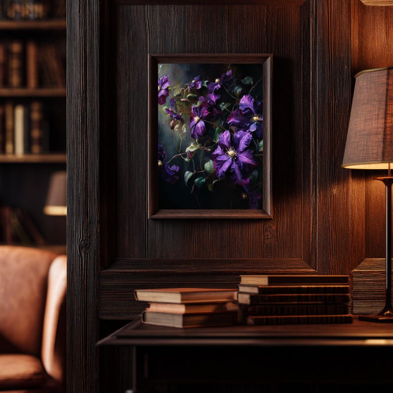 May include: A framed floral print featuring vibrant purple flowers with green foliage. The artwork is displayed on a dark wood-paneled wall, with a warm-toned lamp and a stack of books visible in the background, creating a cozy, classic aesthetic.