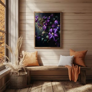 May include: A framed floral print featuring vibrant purple clematis flowers with green leaves. The artwork hangs above a wooden bench with orange and white pillows. A woven basket with tall, dried grasses sits near a window.