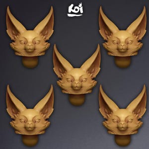 May include: Five identical tan-coloured sculpted animal heads with large, pointed ears and detailed facial features arranged in a pentagon pattern. The word Koi is printed in white text at the top centre of the image above the animal heads.