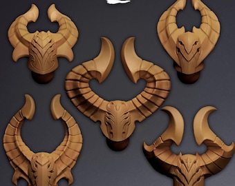 Puede incluir: Cinco objetos de color tostado con forma de casco con cuernos dispuestos en grupo sobre un fondo oscuro. Cada pieza presenta una placa frontal central con cuernos curvos simétricos que se extienden hacia arriba. La palabra Koi aparece en blanco.