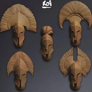 May include: Five tan-colored miniature helmets arranged in a group. Four helmets feature large, textured crests extending from the top, while the central helmet has a smaller, rounded top piece. Each helmet displays a pointed faceplate design.