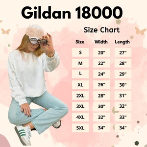 May include: White Gildan 18000 sweatshirt with a size chart. The chart lists sizes S to 5XL, with widths from 20" to 34" and lengths from 27" to 34". The model is wearing the sweatshirt and light blue jeans.