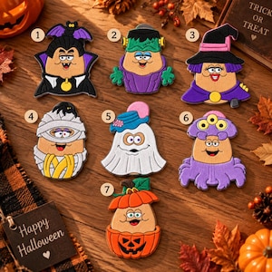 Könnte beinhalten: Ein Set aus sieben hölzernen Halloween-Figuren, nummeriert von eins bis sieben. Die Charaktere umfassen einen Vampir, Frankensteins Monster, eine Hexe, eine Mumie, ein Gespenst, einen dreiaugigen Außerirdischen und einen Kürbis mit bunten Details.
