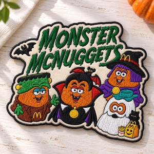 May include: An embroidered patch featuring the text MONSTER MCNUGGETS in green. It depicts four orange nugget characters dressed as a Frankenstein monster, a vampire, a witch, and a ghost, with a small black bat and a McDonald's fry box.