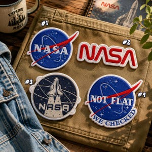 Pode incluir: Quatro emblemas bordados com temas da NASA. O número 1 é o logótipo circular azul da NASA. O número 2 é o logótipo vermelho da NASA. O número 3 é um emblema circular com um vaivém espacial e o texto NASA. O número 4 é um emblema azul com o texto NOT FLAT WE CHECKED.