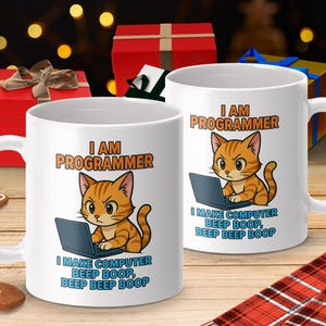 Peut inclure: Deux mugs en céramique blanche avec un chat de dessin animé. Le chat orange et blanc est devant un ordinateur portable. Le texte sur les tasses est "I AM PROGRAMMER" et "I MAKE COMPUTER BEEP BOOP, BEEP BEEP BOOP."