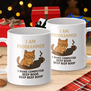 May include: Two white ceramic mugs with the text "I AM PROGRAMMER" and a cartoon cat wearing glasses and working on a laptop. The mugs also have the text "I MAKE COMPUTER BEEP BOOP, BEEP BEEP BOOP".