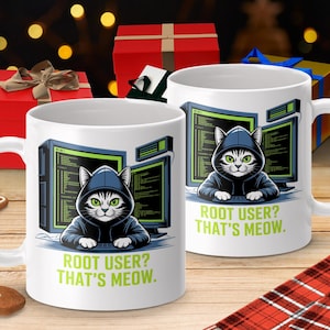 May include: White ceramic mug featuring a cartoon cat wearing a hoodie, sitting in front of computer monitors. The text "ROOT USER? THAT'S MEOW." is printed in green. The background includes gift boxes and bokeh lights.