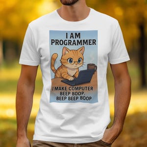 以下が含まれることがあります： メガネをかけた猫がノートパソコンで作業している漫画の白いTシャツ。「I AM PROGRAMMER」と「I MAKE COMPUTER BEEP BOOP, BEEP BEEP BOOP」の文字が猫のイラストの上と下にプリントされています。