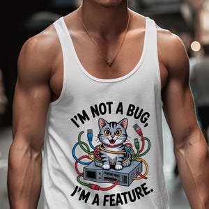 May include: White vest top featuring a cartoon cat tangled in wires, sitting on a grey electronic device. The text reads "I'M NOT A BUG, I'M A FEATURE."