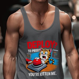 May include: A grey vest top featuring a cartoon cat pressing a red button, with the text "DEPLOY? TO PROD? YOU'RE KITTEN ME." The cat is orange and black, with a surprised expression. The design includes computer screens and a red book.