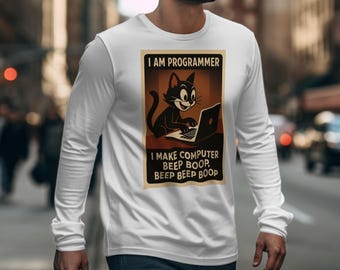 以下が含まれることがあります： 白い長袖Tシャツ。ノートパソコンで作業する漫画の猫のグラフィックが特徴です。「I AM PROGRAMMER」と「I MAKE COMPUTER BEEP BOOP, BEEP BEEP BOOP」のテキストが長方形のフレームに収められています。
