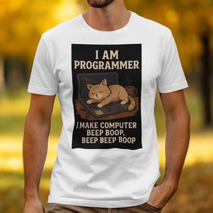 May include: White t-shirt with a black rectangle featuring the text "I AM PROGRAMMER" above an illustration of a cat sleeping on a laptop. Below the cat is the text "I MAKE COMPUTER BEEP BOOP, BEEP BEEP BOOP."