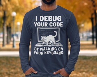 May include: Navy blue long-sleeve shirt with the text "I Debug Your Code By Walking On Your Keyboard." The design features a white cat on a computer screen. The shirt is a comfortable, casual wear.