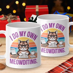 Peut inclure: Deux mugs en céramique blanche avec un motif de chat. Le chat porte des lunettes et tape sur un clavier, avec le texte "I DO MY OWN MEOWDITING." Les mugs sont sur une surface en bois avec des boîtes cadeaux en arrière-plan.