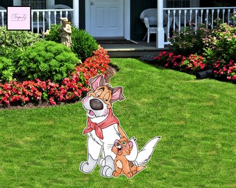 May include: A cartoon cutout of a dog and cat, set on a green lawn. The dog is white and brown with a red bandana. The cat is orange and white. The background includes a white porch, flowers, and green bushes.