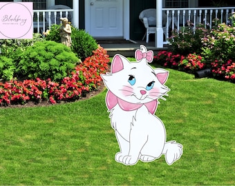 Op de afbeelding: Een witte cartoonkat met een roze strik en kraag zit op een groen gazon. De kat heeft blauwe ogen en roze accenten. De achtergrond omvat een tuin met rode bloemen en groene struiken. De afbeelding heeft een roze cirkel met de tekst "Blackberry Printables".