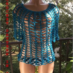 Può includere: Un top in crochet blu turchese con un designo sciolto e a trama aperta. Il top ha una scollatura rotonda e maniche corte.