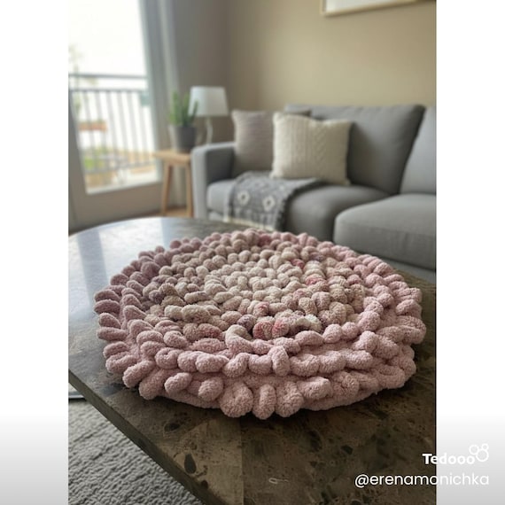 Round loops decorative rug in neutral colors 2 feet around.