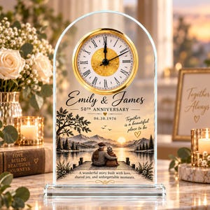 May include: An arched glass mantel clock featuring a gold-rimmed analog face with Roman numerals. The glass surface displays the text Emily & James, 50th Anniversary, 06.30.1976, and a printed illustration of a couple sitting on a wooden pier by a lake.
