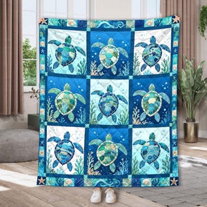May include: A quilted throw blanket featuring a grid of nine squares, each displaying a sea turtle in shades of blue and green. The background of each square alternates between light and dark blue, decorated with bubbles, coral, and sea life motifs.