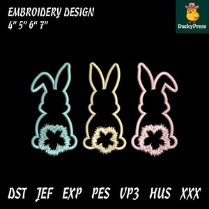 May include: Three bunny embroidery designs in light blue, yellow, and pink, each with a fluffy tail. The text "EMBROIDERY DESIGN 4" 5" 6" 7"" is at the top. The image also includes the text "DST JEF EXP PES UP3 HUS XXX".