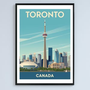 May include: A framed art print featuring a stylized illustration of the Toronto skyline. The image includes the CN Tower, other skyscrapers, and the text "TORONTO CANADA" in a vintage travel poster style. The color palette includes shades of blue, beige, and brown.