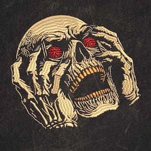 May include: Embroidered skull patch with gold thread, red eyes, and an open mouth. The skull is clutching its head with skeletal hands, set against a dark, textured background. A detailed, gothic-themed design.