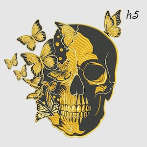 Puede incluir: Diseño de calavera negra y dorada con mariposas. La calavera es negra con detalles dorados, y las mariposas son doradas. La imagen incluye el texto "h5" en la esquina superior derecha.