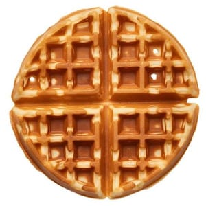 Może przedstawiać: Zbliżenie na okrągły, złocistobrązowy gofr, podzielony na cztery segmenty. Gofry mają wzór kratki z kwadratowymi wgłębieniami. Obraz podkreśla teksturę i szczegóły pieczonego produktu śniadaniowego.