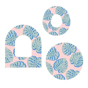 Może przedstawiać: Trzy dekoracyjne kształty: łuk, okrąg i pierścień. Każdy kształt ma różowe tło z powtarzającym się wzorem niebieskich i zielonych liści monstery. Kształty są odizolowane na białym tle.
