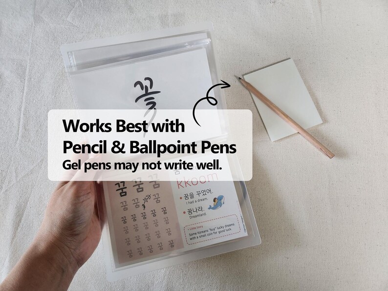 May include: A clear plastic pouch containing educational practice sheets with Korean characters and illustrations, including the text 'Works Best with Pencil & Ballpoint Pens. Gel pens may not write well.' A wooden pencil rests on a small white notepad.