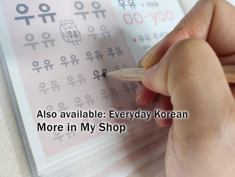 May include: A light-colored educational worksheet featuring rows of the Korean Hangul characters for milk, written as '우유', alongside a small cartoon milk carton illustration, with text including 'oo-yoo' and 'milk' printed in black and red ink.