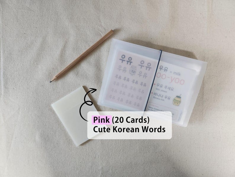 May include: A set of twenty pink Korean vocabulary cards housed in a translucent frosted plastic case with a black elastic band closure, accompanied by a wooden pencil and a small matching translucent plastic card holder.