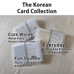 May include: Three sets of rectangular flashcards in translucent frosted plastic cases, each secured with a thin black elastic band. The cards feature Korean text, English translations, and phonetic pronunciations, labeled as Cute Words, Everyday, and Fun Sounds.